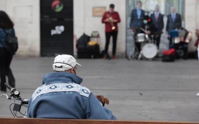 Una persona mayor sentada en un banco Una persona mayor sentada en un banco