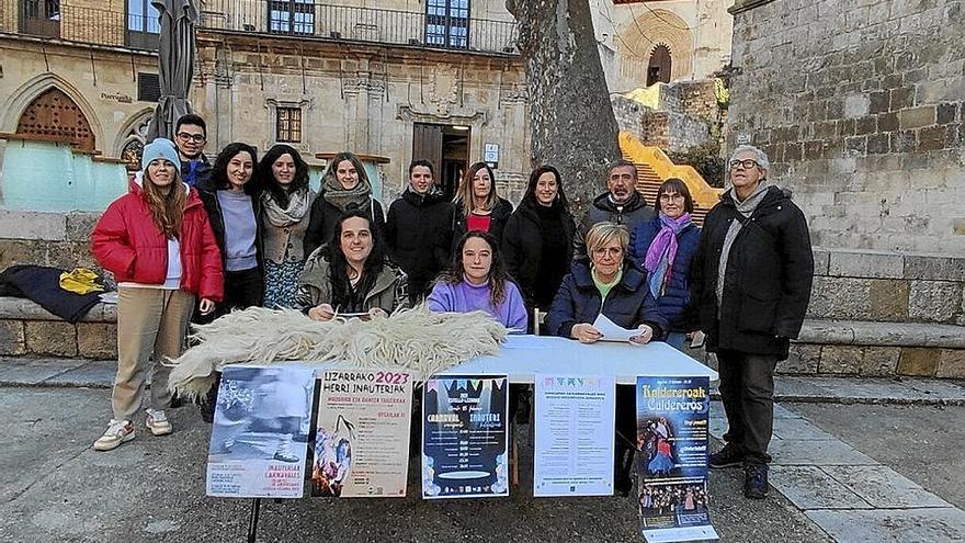 Representantes de la comisión de carnaval con Yolanda Alen (d), Uxue Zamorano y Judit Moreno sentadas en la mesa en la plaza de San Martín de Estella. | FOTO: JAVIER ARIZALETA