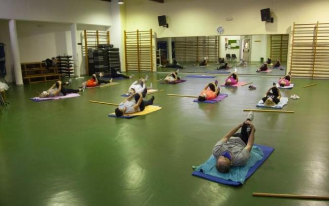 Varias personas realizan estiramientos en un centro cívico de Vitoria.