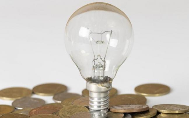Imagen de una bombilla sobre monedas de euro. Imagen de una bombilla sobre monedas de euro.