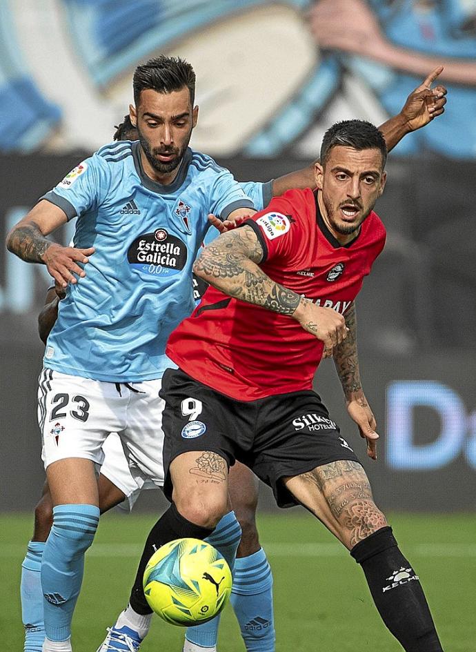 Joselu, en la imagen peleando por un balón con Brais, no pasa actualmente por su mejor momento. Foto: Área 11