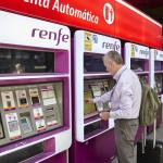 Una persona en una de las máquinas de venta de billetes en la estación Madrid-Atocha Cercanías.