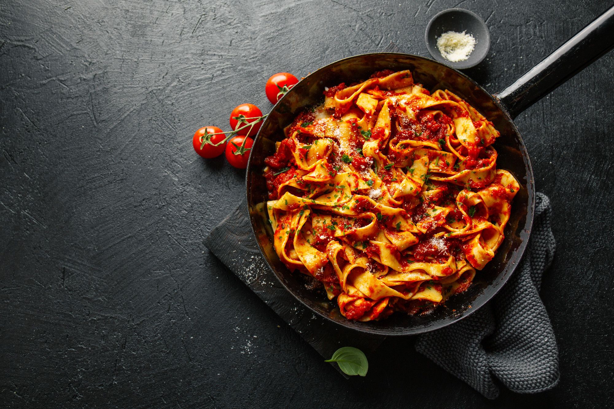 Una sartén llena de pasta con tomate.