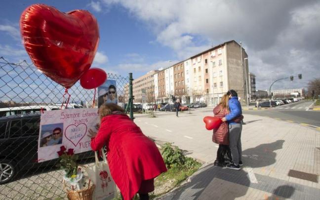 Familiares de los dos jóvenes colocan en la acera del atropello fotos de la pareja.