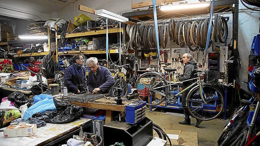 El equipo de reparación de bicicletas de la ONG Ayuda Contenedores, en su taller.