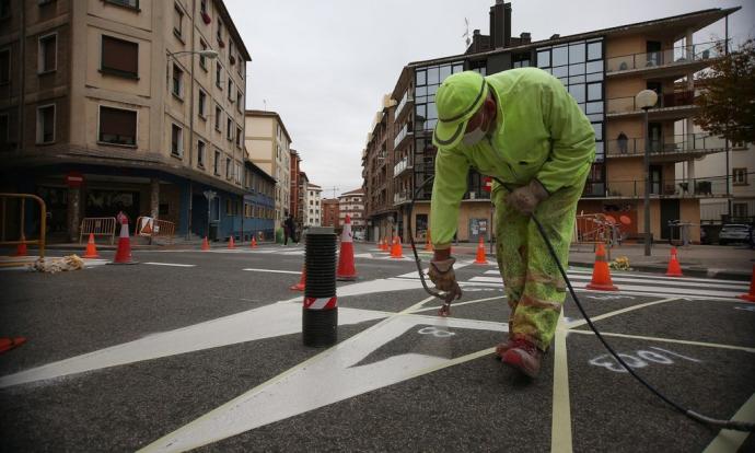 Trabajadores pintando el cruce de las calles Manuel de Falla y Río Urrobi durante las obras de reurbanización para ampliar el espacio peatonal.