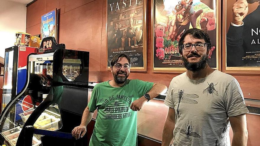 Edorta Martínez y Xabier Amenabarro junto a la cartelera y el estand de dulces y palomitas.