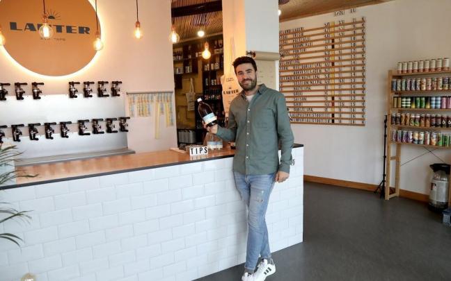 Diego Polo posa en Lauter Craft Beer, con los 18 grifos de cerveza a granel y la pizarra donde est&aacute;n escritas las variedades de cervezas que ofrece.