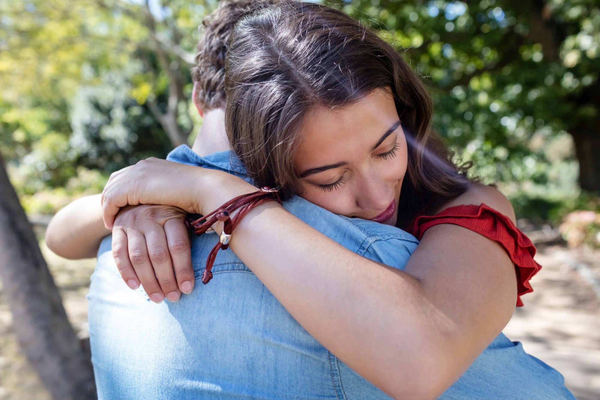 Una joven se abraza a su pareja.
