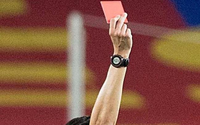 Un árbitro muestra una tarjeta roja. Un árbitro muestra una tarjeta roja.