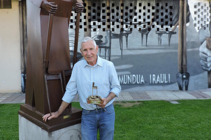 Félix Lizarraga posa junto a su escultura en homenaje a los laiaris con el premio que le acredita como Laya de Oro 2021.