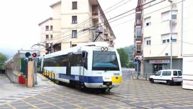 Un unidad de Renfe de ancho métrico cruza un paso a nivel en Zalla