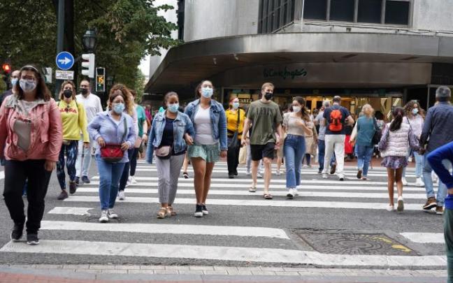 Varias personas pasean protegidas con mascarillas por la pandemia de coronavirus Varias personas pasean protegidas con mascarillas por la pandemia de coronavirus