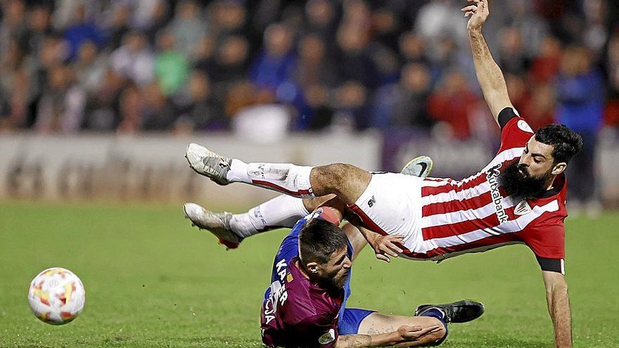Asier Villalibre es derribado por Kaiser, en un lance del encuentro de Copa disputado ayer entre el Alzira y el Athletic. | FOTO: EFE