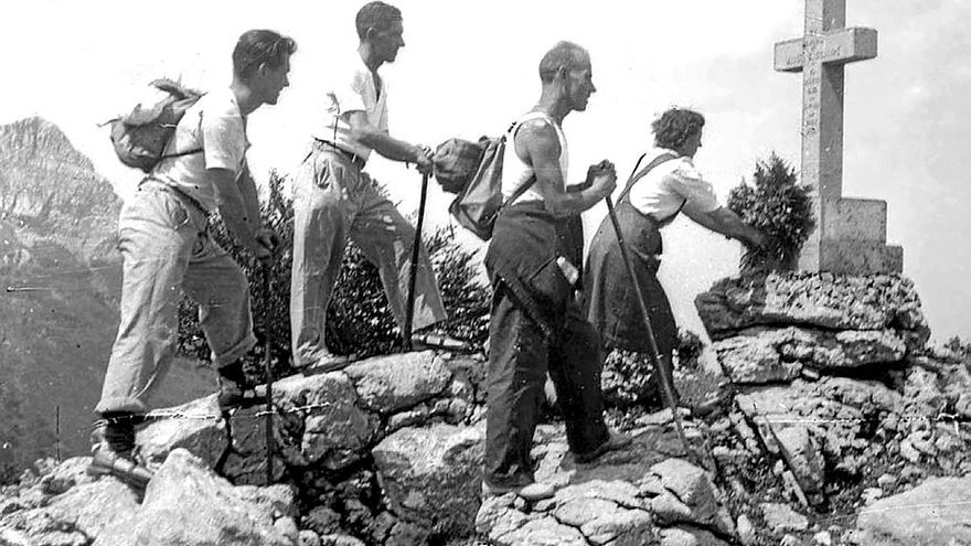 Montañeros de Eibar depositan flores en la cruz.