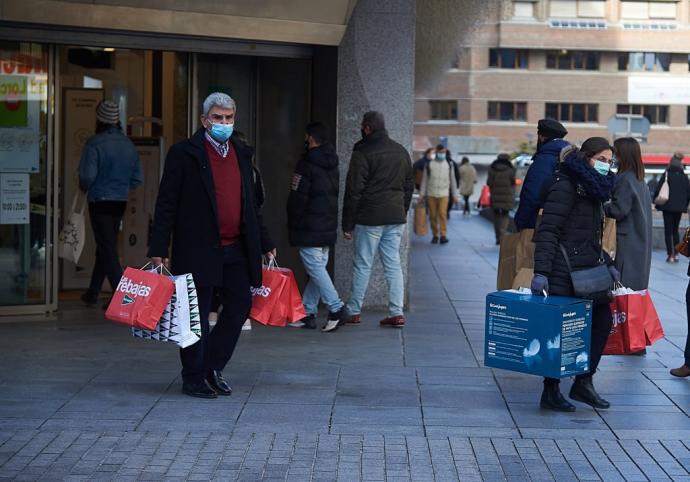 Varias personas portan bolsas tras las compras de rebajas.