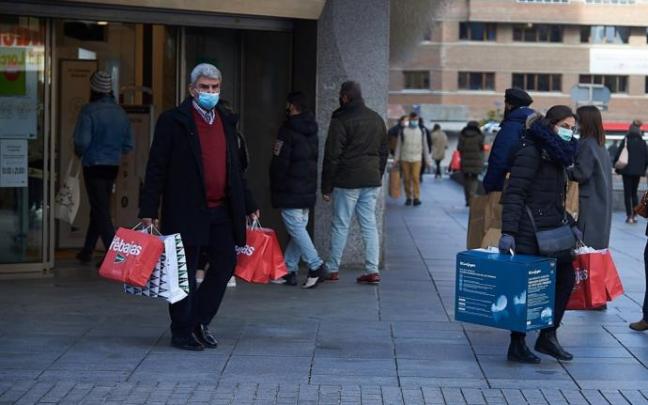 Varias personas portan bolsas tras las compras de rebajas.