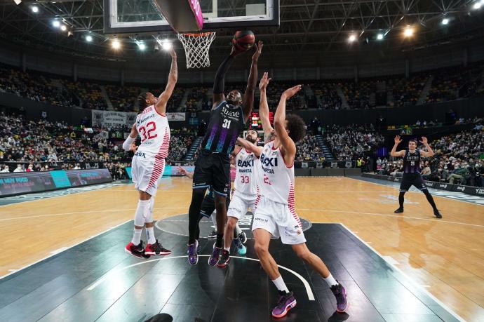 Ángel Delgado anota rodeado por jugadores del Baxi Manresa.