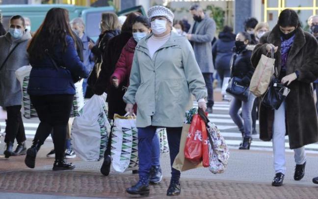 Una persona pasea por la Gran Vía cargada de bolsas. Una persona pasea por la Gran Vía cargada de bolsas.