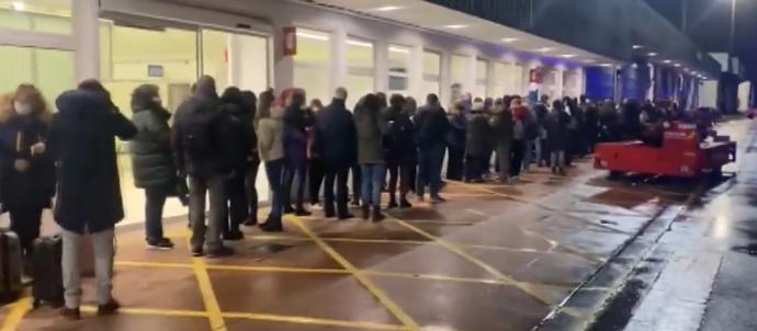 Pasajeros haciendo cola a la intemperie para poder acceder al aeropuerto tras bajar del avión