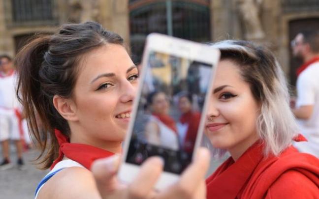 Jóvenes haciéndose un "selfie" con el teléfono móvil en San Fermín.