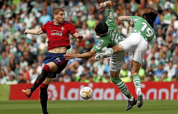 Darko, Bartra y Bellerín, aterrizando tras saltar a por un balón que cae al césped. Foto: Efe