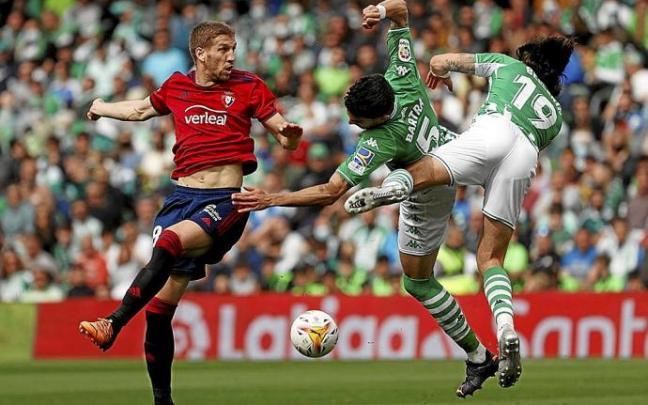 Darko, Bartra y Bellerín, aterrizando tras saltar a por un balón que cae al césped. Foto: Efe