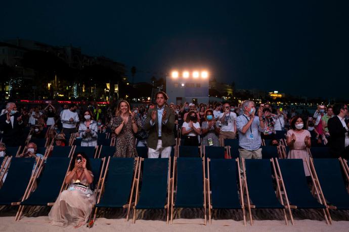 Un grupo de personas asisten a una película en una playa de Cannes