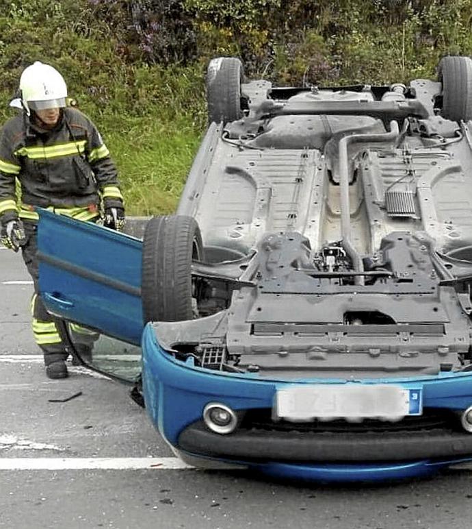 Bombero junto a un vehículo volcado en la A-625. Foto: Bomberos de Álava