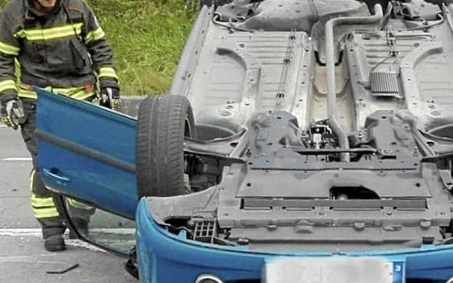 Bombero junto a un vehículo volcado en la A-625. Foto: Bomberos de Álava