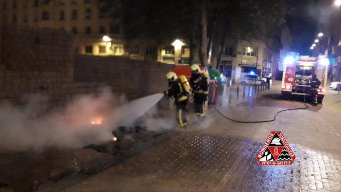 Bomberos apagando el contenedor incendiado en la calle Fueros.