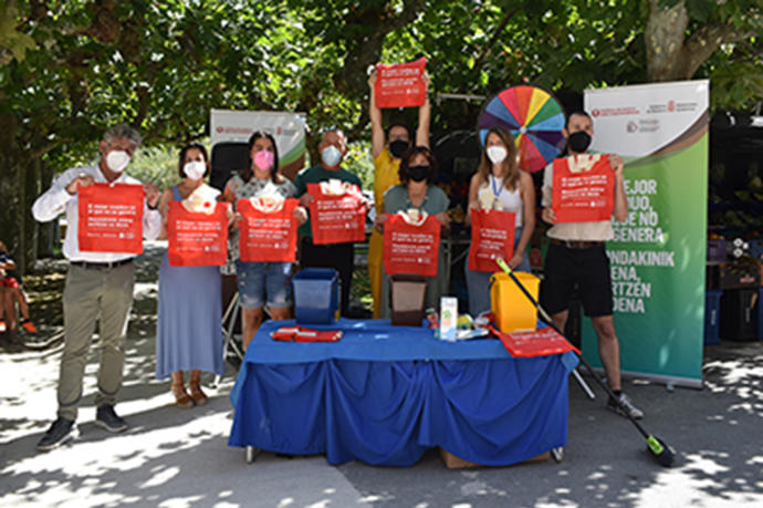 Autoridades de las entidades implicadas en la campaña posando en el stand situado en el mercadillo de Funes