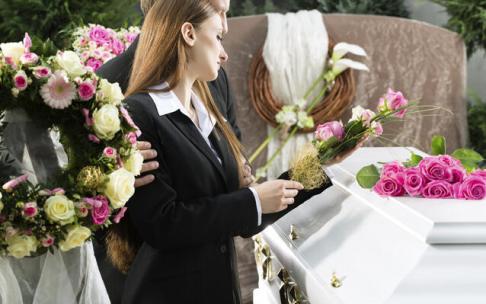 Mujer colocando flores en un ataúd