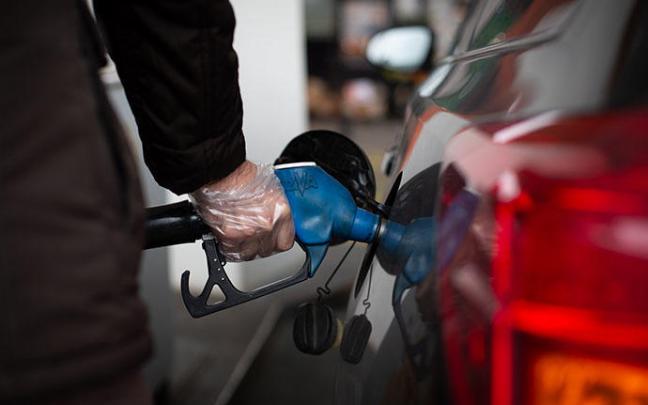 Un hombre reposta en una gasolinera. Un hombre reposta en una gasolinera.