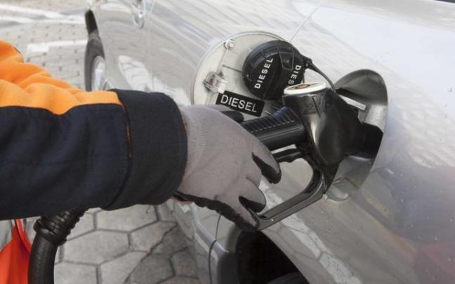 Trabajador llenando un coche de gasóleo en una gasolinera. Trabajador llenando un coche de gasóleo en una gasolinera.