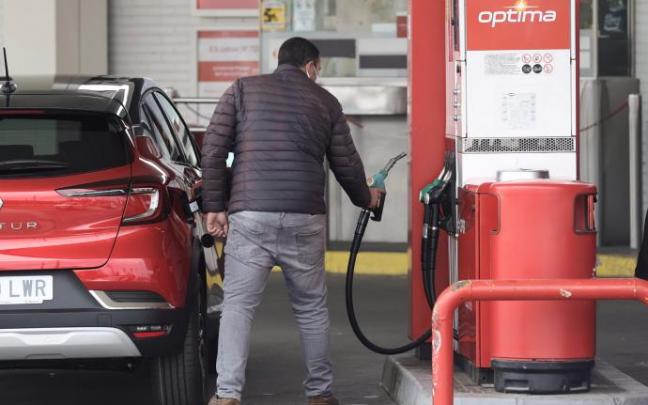Un hombre reposta en una gasolinera. Un hombre reposta en una gasolinera.