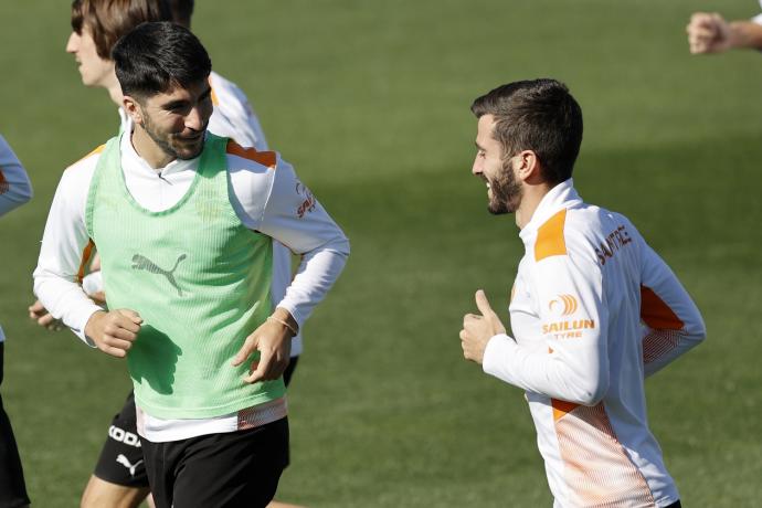 Carlos Soler charla con Gayá durante el entrenamiento de hoy martes del Valencia.