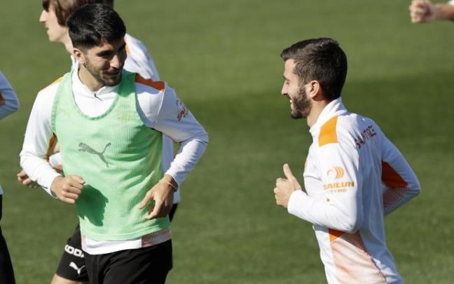 Carlos Soler charla con Gayá durante el entrenamiento de hoy martes del Valencia.