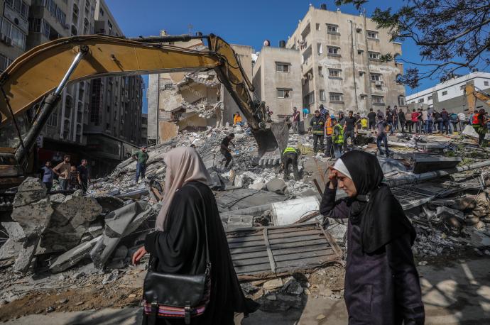 Varias personas buscan supervivientes entre los escombros de una casa destruida después de un ataque aéreo israelí en la ciudad de Gaza.