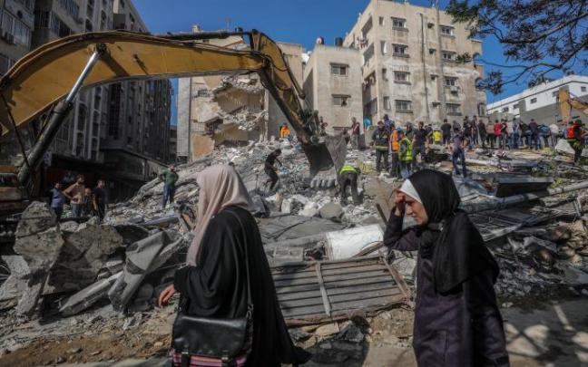 Varias personas buscan supervivientes entre los escombros de una casa destruida después de un ataque aéreo israelí en la ciudad de Gaza. Varias personas buscan supervivientes entre los escombros de una casa destruida después de un ataque aéreo israelí en la ciudad de Gaza.