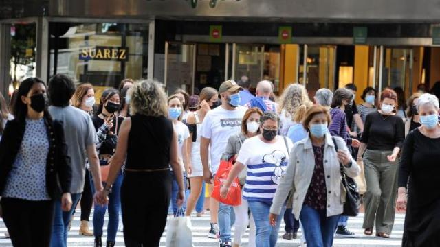 Ciudadanos con mascarilla cruzando una calle.