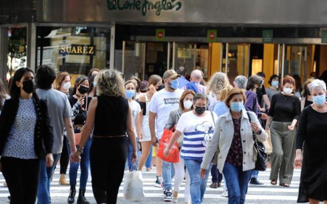 Ciudadanos con mascarilla cruzando una calle. Ciudadanos con mascarilla cruzando una calle.