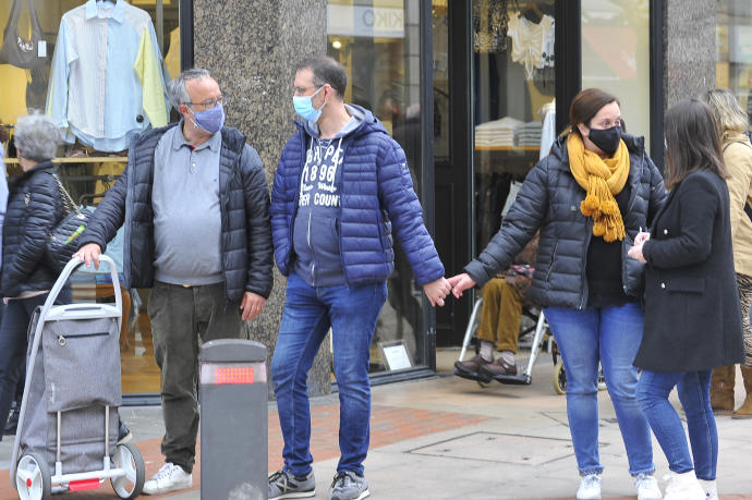 Personas por la calle con mascarilla.