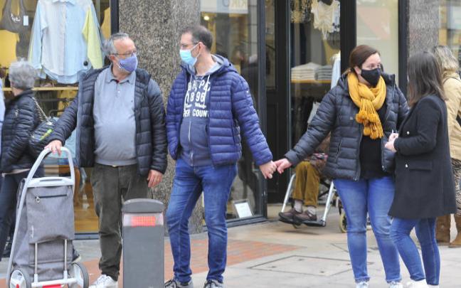 Personas por la calle con mascarilla.