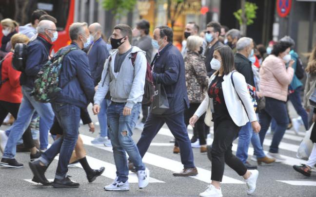 Varias personas pasean con la mascarilla puesta