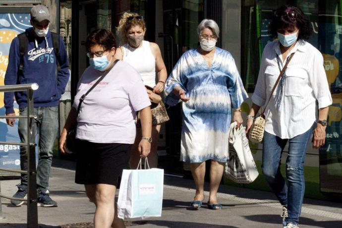 Gente paseando en Vitoria con mascarilla.