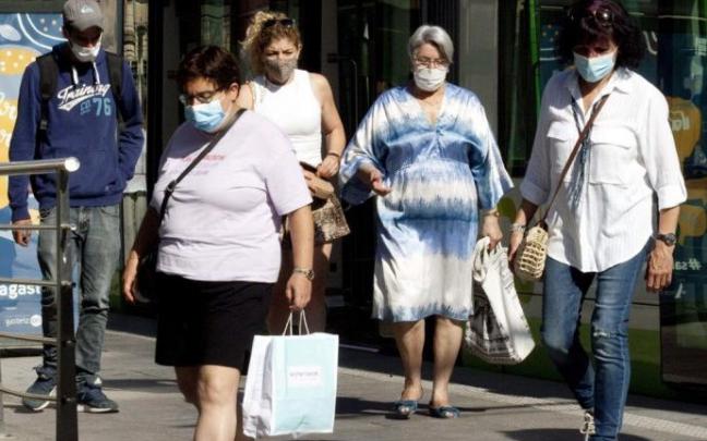 Gente paseando en Vitoria con mascarilla.