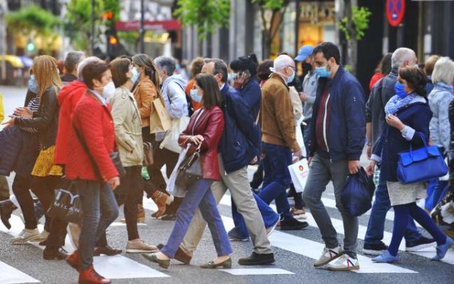 Gente paseando con la mascarilla.