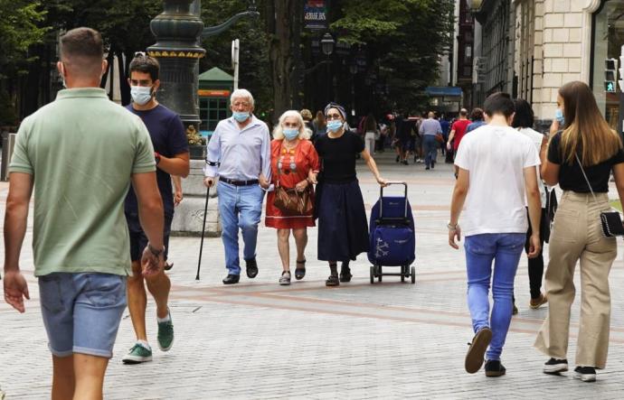 Personas con mascarilla por la calle en Bilbao