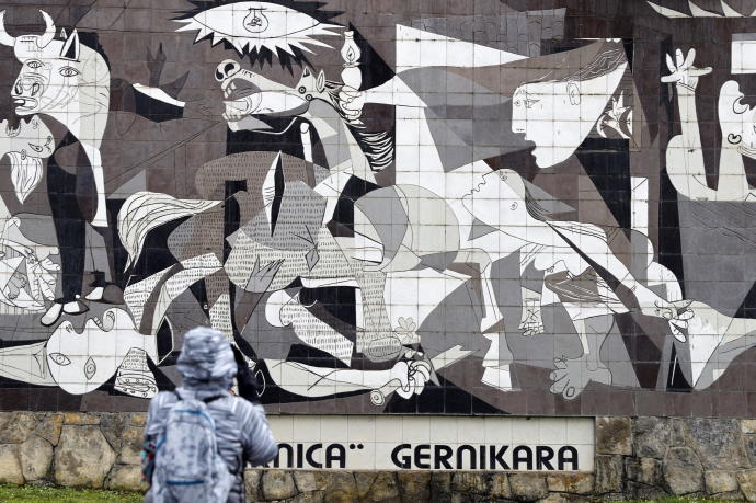 Una persona observa una réplica del cuadro de Picasso que retrata el horror del bombardeo de Gernika.